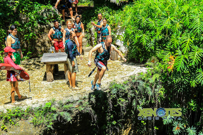 Chris jumping off a cliff at Káa'k'. Photo by Jaime of Xenotes Oasis Maya.