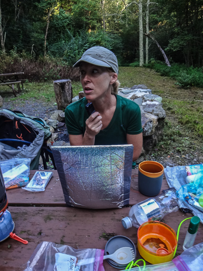 Julie recording her thoughts, waiting for breakfast to cook (i.e. rehydrate). That silver rectangular thingy is an insulating food cozy.