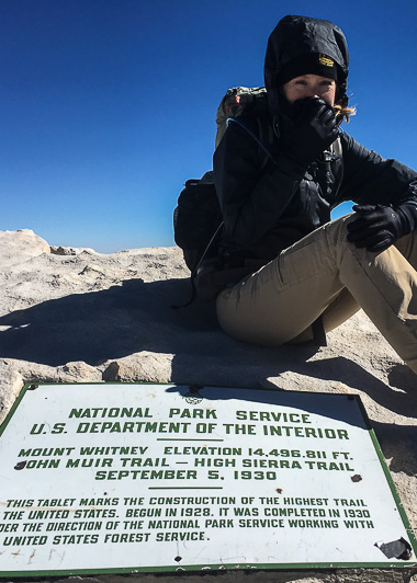 At the summit of Mt. Whitney. Windy and cold! I was wearing mittens too, but took them off to snap photos and video.