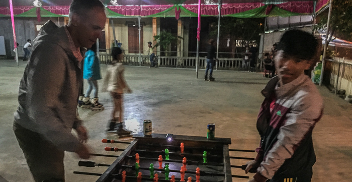 Chris and Bang playing foosball in a corner of the Khe Sanh outdoor roller rink and rec area.