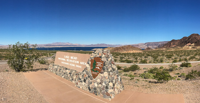 Sign near the parking lot entrance, with Lake Mead in the background